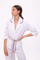 Blazer blanco con solapas con borde marrón, corte recto, mangas 3/4 y cinturón marrón.