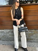 Pantalón de vestir color beige con finas rayas verticales negras, de corte recto y tiro alto.