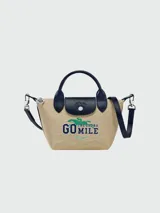 Bolso Longchamp modelo Le Pliage Collection XS, color beige con detalles en azul marino y logo "Go Mile" estampado en verde.