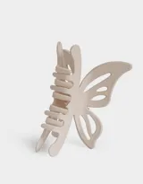 Broche para el cabello color beige con forma de mariposa.