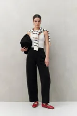 Pantalón de jean negro de tiro alto y corte amplio con forma curva.