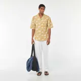 Pantalón blanco de corte recto y estilo casual, con múltiples bolsillos y cierre frontal con botón y cremallera.
