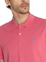 Chomba color salmón de piqué de algodón pima, con cuello clásico, tapeta de dos botones y logo bordado en el pecho.