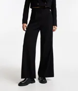 Pantalón de vestir negro de corte recto, con bolsillos laterales y traseros. Se ajusta a la cintura con cierre de botón y cremallera.