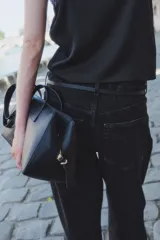 Pantalón jean negro de tiro alto, corte ancho y recto, con cinco bolsillos y cierre con botón.