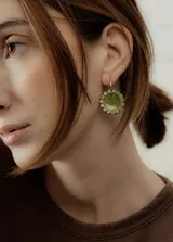 Aros colgantes con dije circular de resina verde con borde de strass y arito de acero quirúrgico.