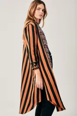 Saco largo con estampado de flores y rayas verticales en tonos naranja, verde y negro.