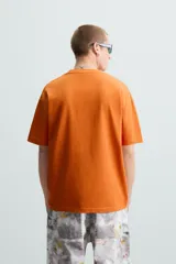 Camiseta color arena de algodón compacto, corte recto, cuello redondo y mangas cortas.