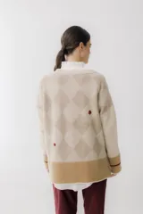 Cárdigan color beige con patrón de rombos en tonos marrones, cierre con botones, bolsillos frontales y bordados de cerezas.