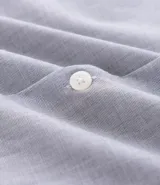 Camisa de hombre color celeste, de corte regular, con cuello inglés, manga larga y abotonado frontal.