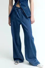Pantalón de denim azul de corte holgado, con cintura elástica ajustable con cordón, bolsillos laterales y piernas anchas.