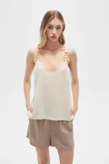 Musculosa color crema de bretel fino con apliques de cadena en los breteles y escote en V.