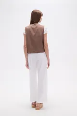 Chaleco sin mangas color marrón topo, con escote en V y bordados intrincados en color crema/blanco que cubren toda la prenda.