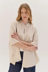 Sobrecamisa celeste de corte recto, con cuello mao, mangas 3/4 con puños y cierre frontal con botones. Tiene dos bolsillos de parche en el pecho.