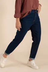 Pantalón jean azul oscuro, corte mom fit, con bolsillos delanteros y traseros, y terminación arremangada.