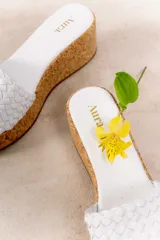 Sandalia con plataforma de corcho y capellada tejida de cuero vacuno color beige.