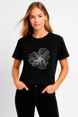 Remera negra de corte clásico con estampado de flor blanca.