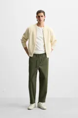 Pantalón de hombre color beige, corte carrot fit, con cintura elástica ajustable con cordón, bolsillos frontales y bolsillo trasero de plastrón.