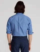 Camisa blanca de corte clásico, confeccionada en tejido oxford de algodón. Presenta cuello button-down, manga larga con puños abotonados y logo bordado en el pecho.