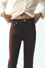 Jeans de tiro alto color marrón, corte slim fit y bootcut, con cinco bolsillos y cierre frontal con cremallera y botón.