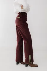 Pantalón de pana marrón con corte acampanado y abertura en el ruedo.