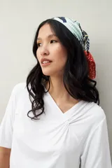 Remera de modal color marrón claro, de manga corta, con cuello asimétrico y detalle de nudo con frunces.