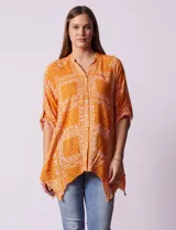 Camisa naranja con estampado cachemir, cuello mao, escote en V y cierre frontal con botones. Mangas 3/4 regulables con presilla y ruedo asimétrico.