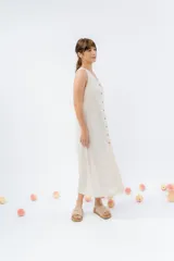 Vestido midi de lino en color verde seco, con escote en V, diseño sin mangas y cierre frontal con botones de madera. Presenta un corte recto y fluido con una abertura frontal en el bajo.