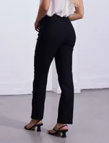 Pantalón de gabardina elastizada color coral, marca Tahari. Corte slim, pretina con pasadores, cierre y broche interno. Delantera y trasera con bolsillos.