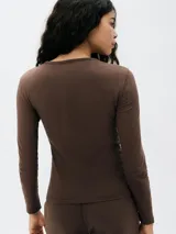 Camiseta básica de manga tres cuartos, color negro, de corte ajustado y cuello redondo.