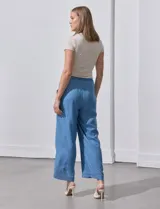 Pantalón capri de lyocell celeste, corte wide leg, con pretina elástica ajustable con lazo y bolsillos delanteros.