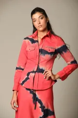 Camisa de manga larga color coral con estampado batik en azul marino, con cuello camisero, cierre frontal con botones, dos bolsillos con solapa en el pecho y corte entallado.