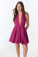 Vestido corto fucsia con escote halter y espalda descubierta.