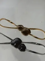 Cinto de metal dorado con hebilla doble irregular.