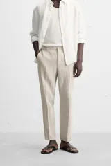 Pantalón de vestir color beige claro, de corte recto y confeccionado en lino.