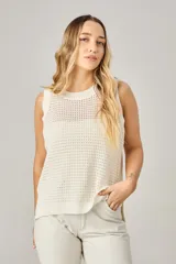 Chaleco de punto calado color blanco, con cuello redondo y sisas anchas.