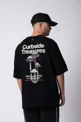 Remera negra oversize de algodón con cuello redondo y mangas cortas. Estampado pequeño en el frente y estampado grande en la espalda con la frase "Curbside Treasure".