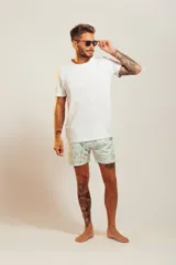 Bañador de hombre color rosa pálido con estampado de golondrinas oscuras. Presenta cintura elástica con cordón ajustable de color crudo y terminales turquesa.