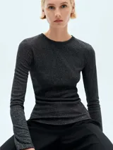 Camiseta negra de tejido de punto fino con lurex, cuello redondo y mangas largas.