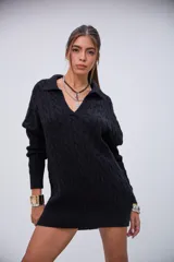 Sweater negro de punto trenzado, con cuello polo y escote en V. Diseño holgado y largo hasta la mitad del muslo.