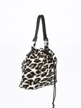 Bandolera tipo bucket con estampado animal print de leopardo en tonos beige y marrón. Tiene cierre con cordón ajustable y correa de hombro extraíble.