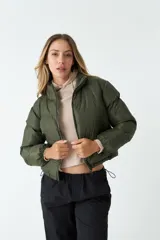 Campera puffer corta color ladrillo, con cuello alto y cierre frontal.