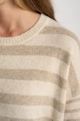 Sweater de punto con cuello redondo, manga larga y diseño de rayas horizontales alternando beige claro y beige melange. Presenta un calce ajustado y un ruedo con aberturas laterales redondeadas.