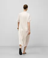 Vestido midi de lino color blanco, corte amplio, escote en pico con festón, manga corta y aberturas laterales.