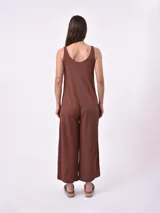 Mono marrón oscuro de corte holgado, con breteles finos y piernas anchas.