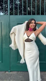 Gargantilla tejida a mano en hilo rosa brilloso con una flor central que aporta un toque romántico y bohemio.