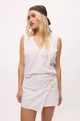 Musculosa blanca de lino con escote en V cruzado.