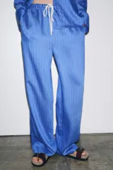 Pantalón de lyocell color azul con rayas verticales, tiro medio, cintura elástica ajustable con cordones y pierna ancha.