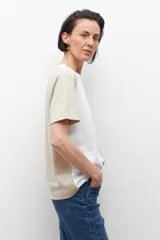 Remera de manga corta con diseño color block en crudo, blanco y negro.