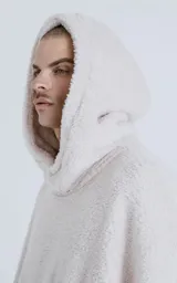 Hoodie blanco de piel de corderito sintético, corte oversize, con capucha ajustable con cordón y bolsillo canguro.
